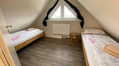 Ein Bett oder Betten in einem Zimmer der Unterkunft Haus Tulle - 2 Ferienwohnungen Schnupp & Lütte mit Saisonstrandkorb
