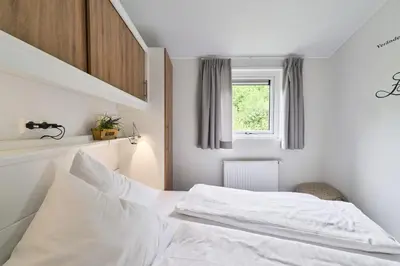 Ein Bett oder Betten in einem Zimmer der Unterkunft Süsel Seeparx Ferienhaus Seeliebe