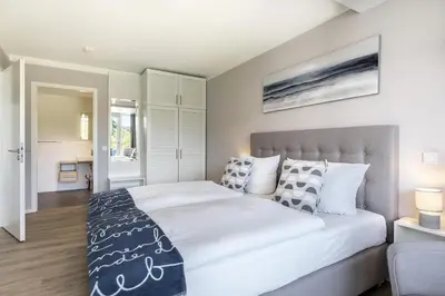 Ein Bett oder Betten in einem Zimmer der Unterkunft Godewindpark Deluxe-Suite 1-04 mit Gartenblick und Loggia