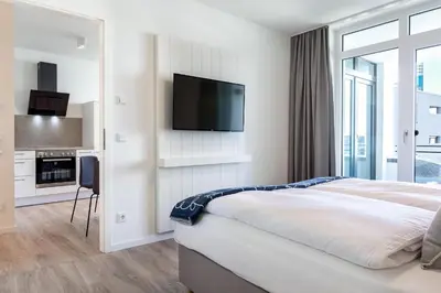 Ein Bett oder Betten in einem Zimmer der Unterkunft Godewindpark Deluxe-Apartment 2-07 mit Strandkorb am Strand