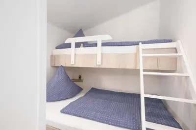 Ein Etagenbett oder Etagenbetten in einem Zimmer der Unterkunft Ostseecamp Lübecker Bucht Haffhuus51 mit kostenfreier Saunanutzung